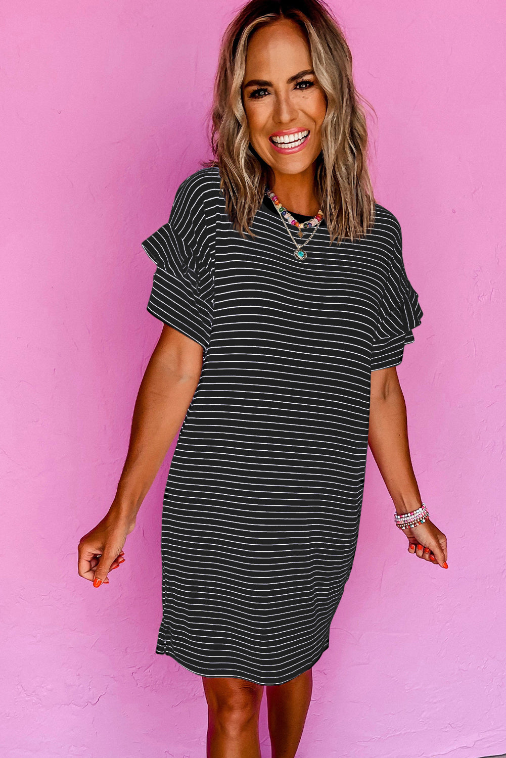 Woman wearing a black striped short-sleeve shift mini dress with ruffled sleeves