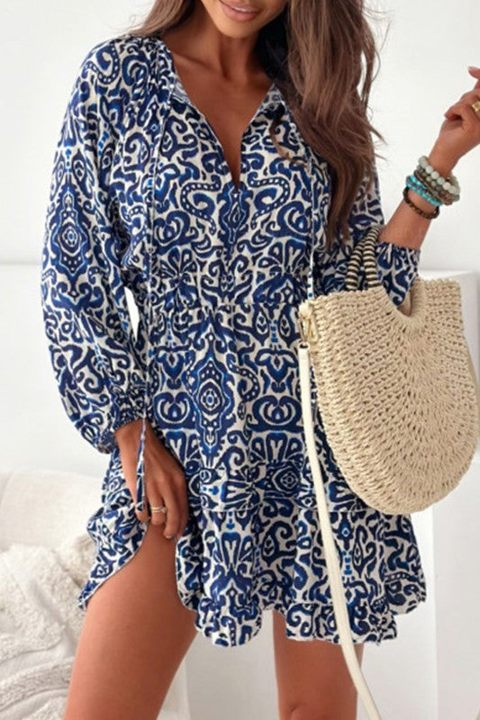 A woman posing in a boho lace-up v-neck dress in a white background. 