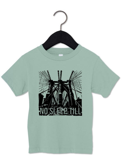 Light green t-shirt with a black graphic and 'No Sleep Till' text on a hanger against a white background