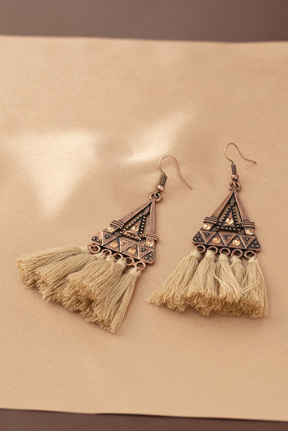 Boho soul, statement style. These earrings are a love letter to laid-back elegance. Featuring a geometric triangle frame in warm-toned metal, finished with cascading brown tassels, they bring movement, texture, and a touch of wanderlust to any outfi