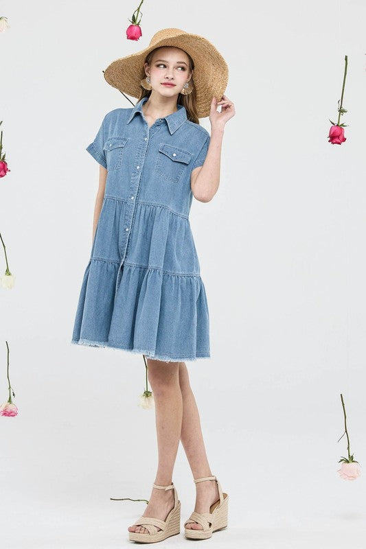 Woman wearing a blue denim dress with a straw hat on a white background