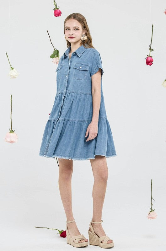 Woman wearing a denim dress with flowers in the background