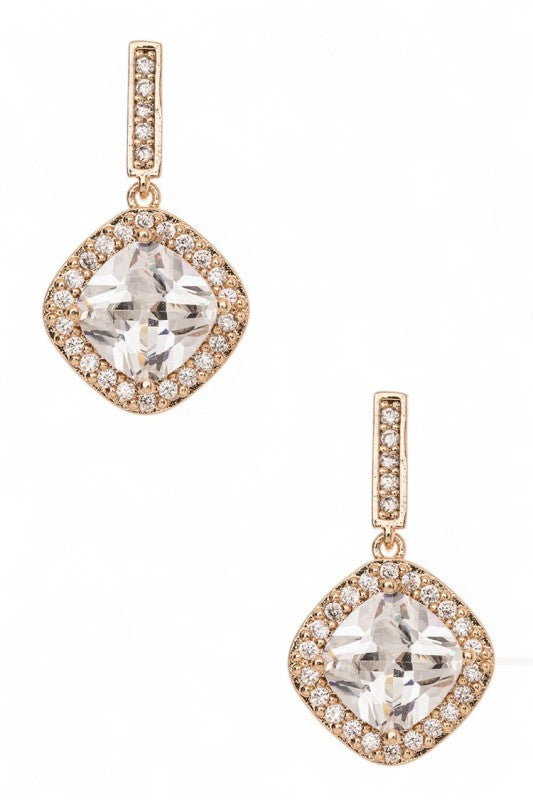 A pair of rose gold dangle earrings with a big clear gemstone in the middle, surrounded by smaller sparkly stones. Got a cute diamond-shaped design.