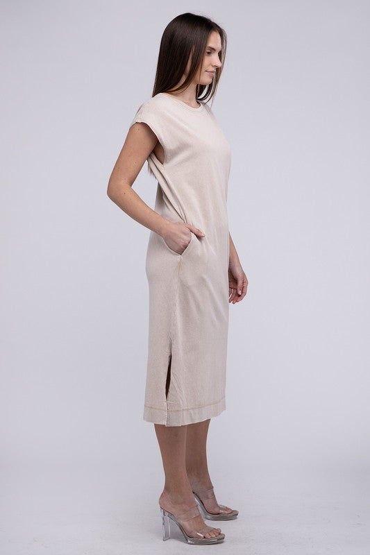 Woman models a comfortable midi dress with a relaxed fit and convenient side pockets, with right hand in pocket.