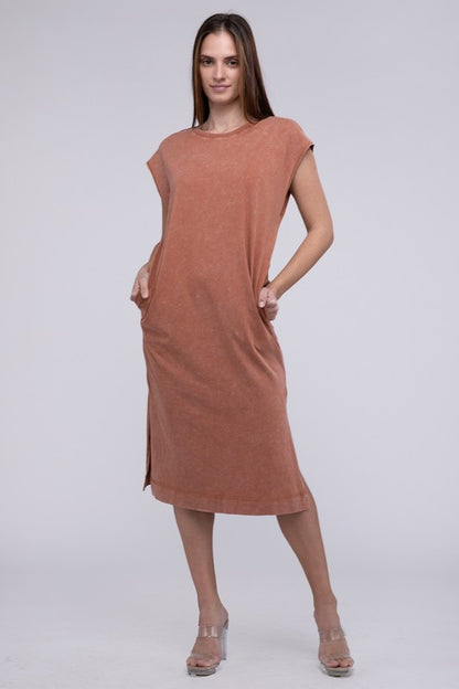 Woman models a comfortable dark tan midi dress with a relaxed fit and convenient side pockets.