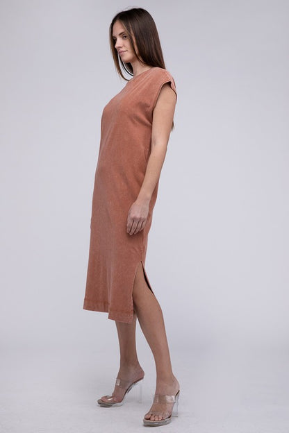 Woman models a comfortable dark tan midi dress with a relaxed fit and convenient side pockets, side view.