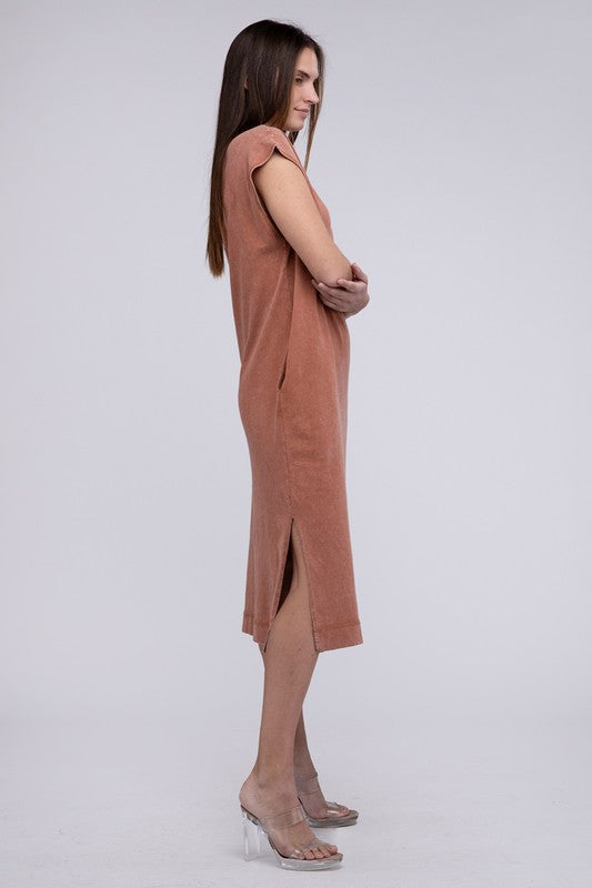 Woman models a comfortable dark tan midi dress with a relaxed fit and convenient side pockets, sideways.