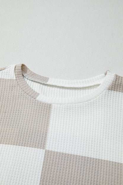 Close-up of a textured shirt with a checkered pattern on a light gray background