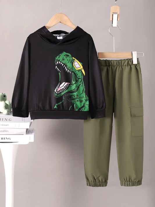 Black hoodie with dinosaur graphic and green pants on hangers against a gray background