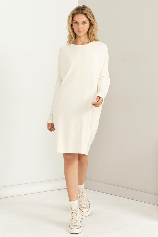 A woman models a white, comfortable oversized Midi Dress with a relaxed fit, perfect for casual wear, in a motion pose.