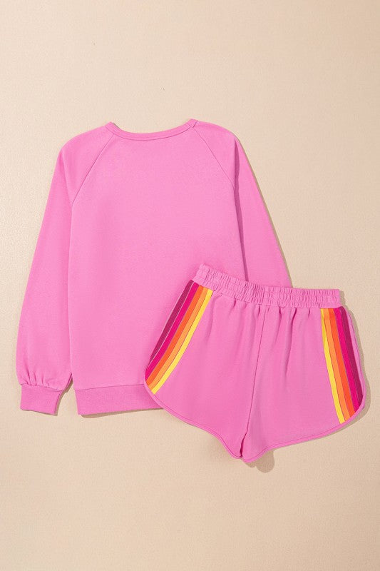 Pink sweatshirt and shorts set with rainbow stripes on a beige background