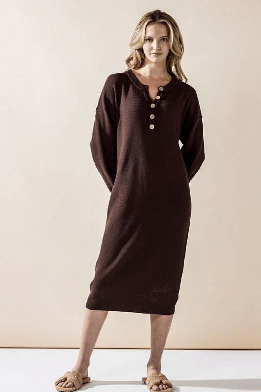 Woman wearing a button-front sweater midi dress with long sleeves and henley neckline.