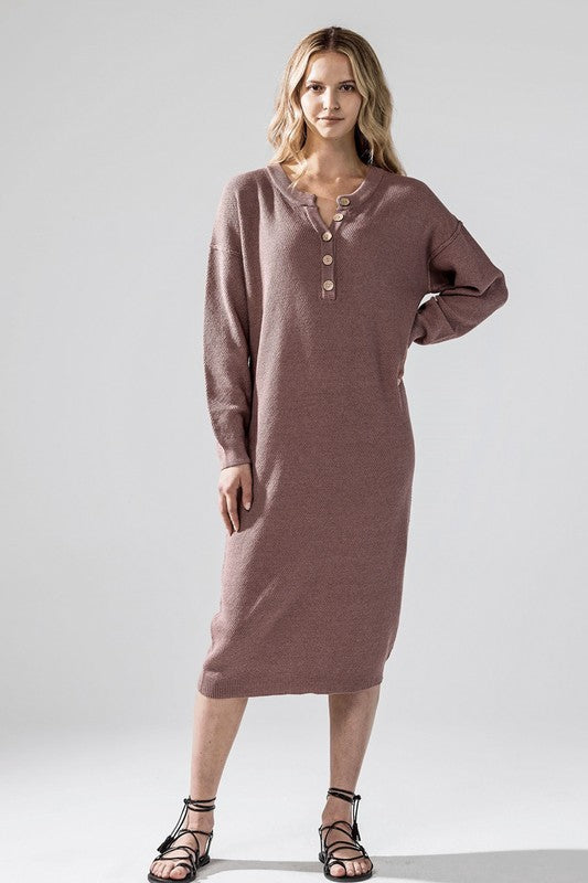 Woman wearing a button-front sweater midi dress with long sleeves and henley neckline.