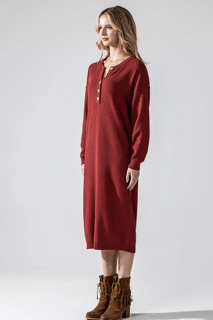 Woman wearing a button-front sweater midi dress with long sleeves and henley neckline.