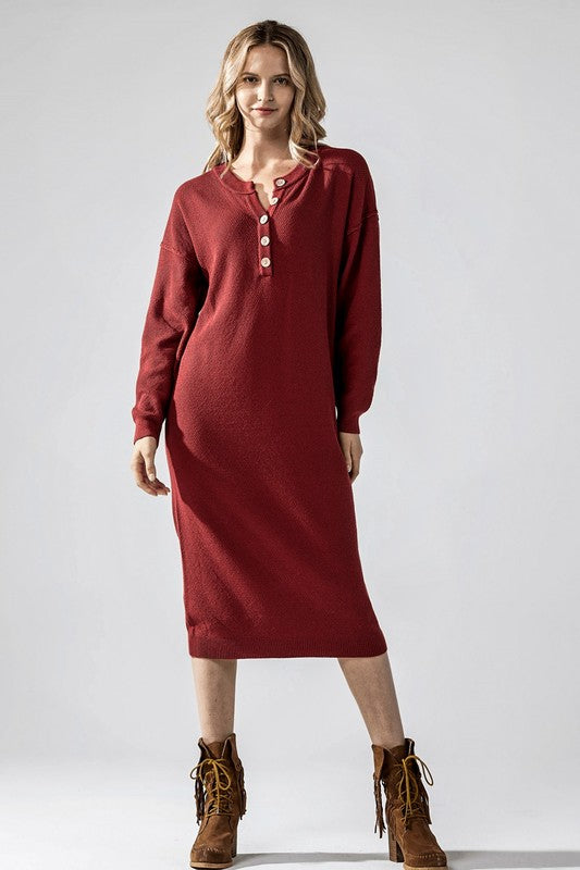 Woman wearing a soft knit button-front midi sweater dress with dropped shoulders and scoop neckline, styled for relaxed comfort.