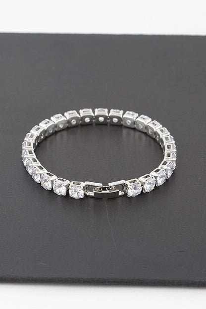 Silver tennis bracelet adorned with round-cut clear gemstones, set in a continuous row for an elegant and classic look.