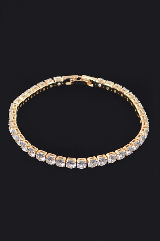 Gold tennis bracelet adorned with round-cut clear gemstones, set in a continuous row for an elegant and classic look.