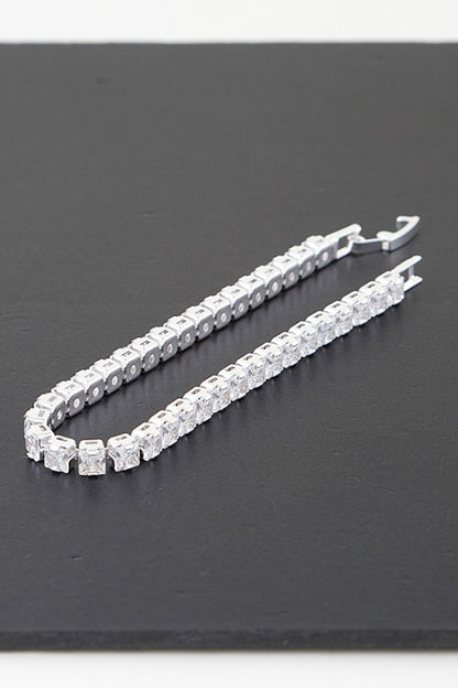 Silver tennis bracelet adorned with round-cut clear gemstones, set in a continuous row for an elegant and classic look.