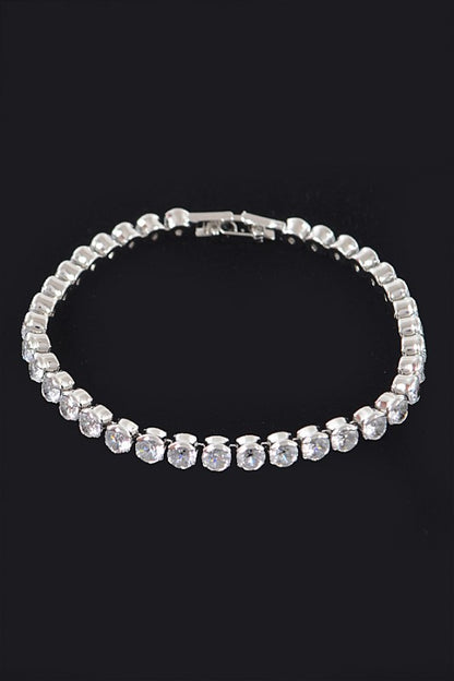 Gold tennis bracelet adorned with round-cut clear gemstones, set in a continuous row for an elegant and classic look.