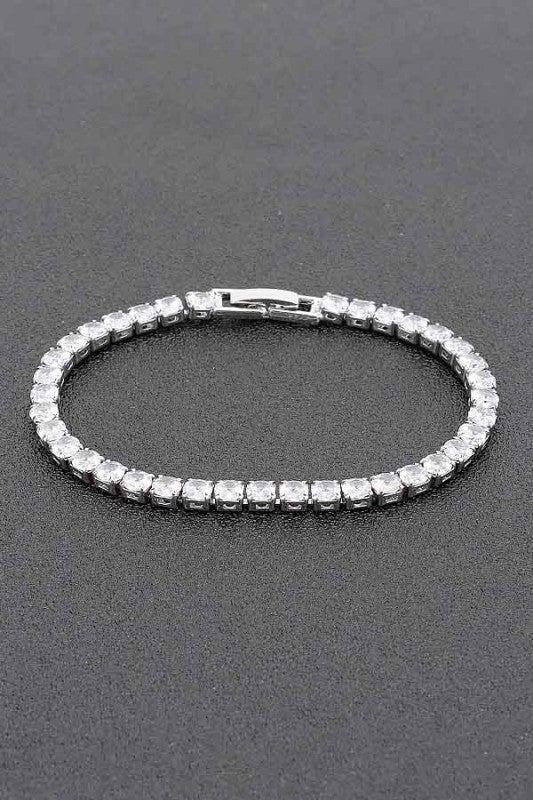 Gold tennis bracelet adorned with round-cut clear gemstones, set in a continuous row for an elegant and classic look.