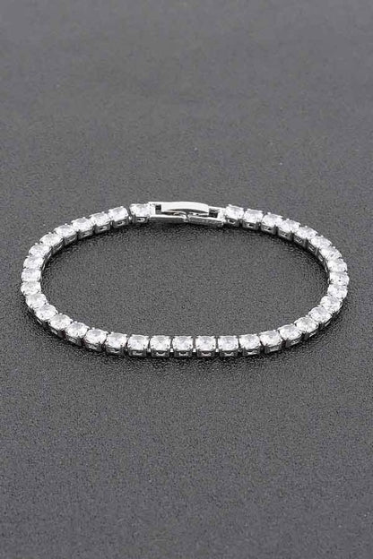 Gold tennis bracelet adorned with round-cut clear gemstones, set in a continuous row for an elegant and classic look.