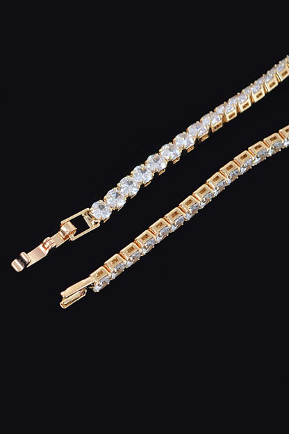 Gold tennis bracelet adorned with round-cut clear gemstones, set in a continuous row for an elegant and classic look.