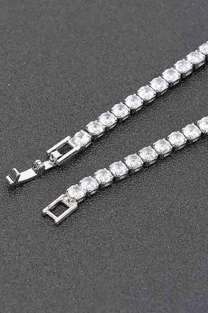 Gold tennis bracelet adorned with round-cut clear gemstones, set in a continuous row for an elegant and classic look.