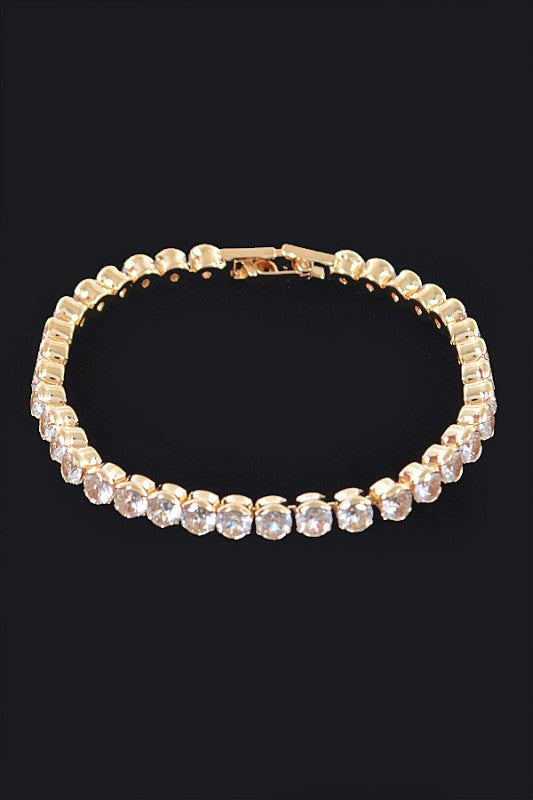 Gold tennis bracelet adorned with round-cut clear gemstones, set in a continuous row for an elegant and classic look.