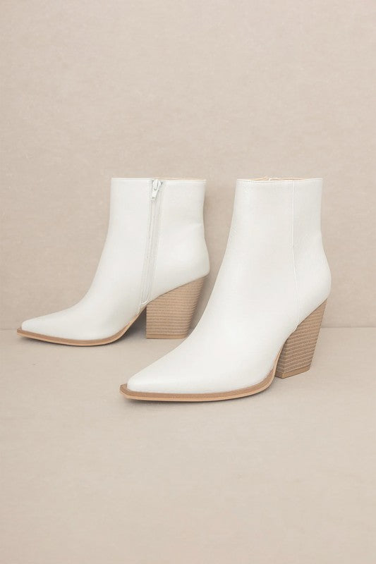 Off-white leather ankle booties featuring pointed toe, textured wood-look block heel, and tan sole trim.