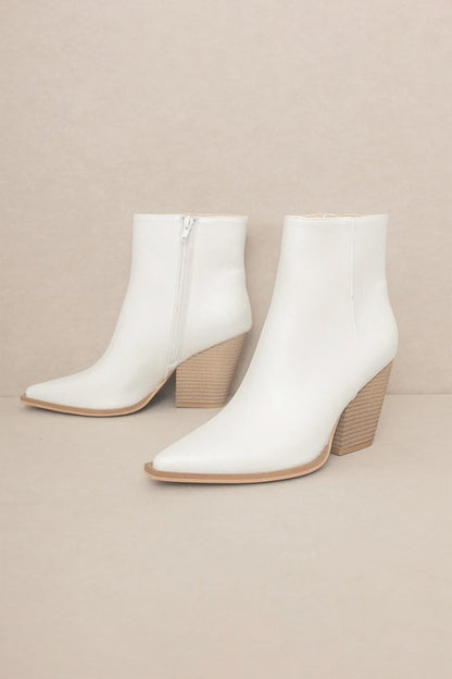 Off-white leather ankle booties featuring pointed toe, textured wood-look block heel, and tan sole trim.