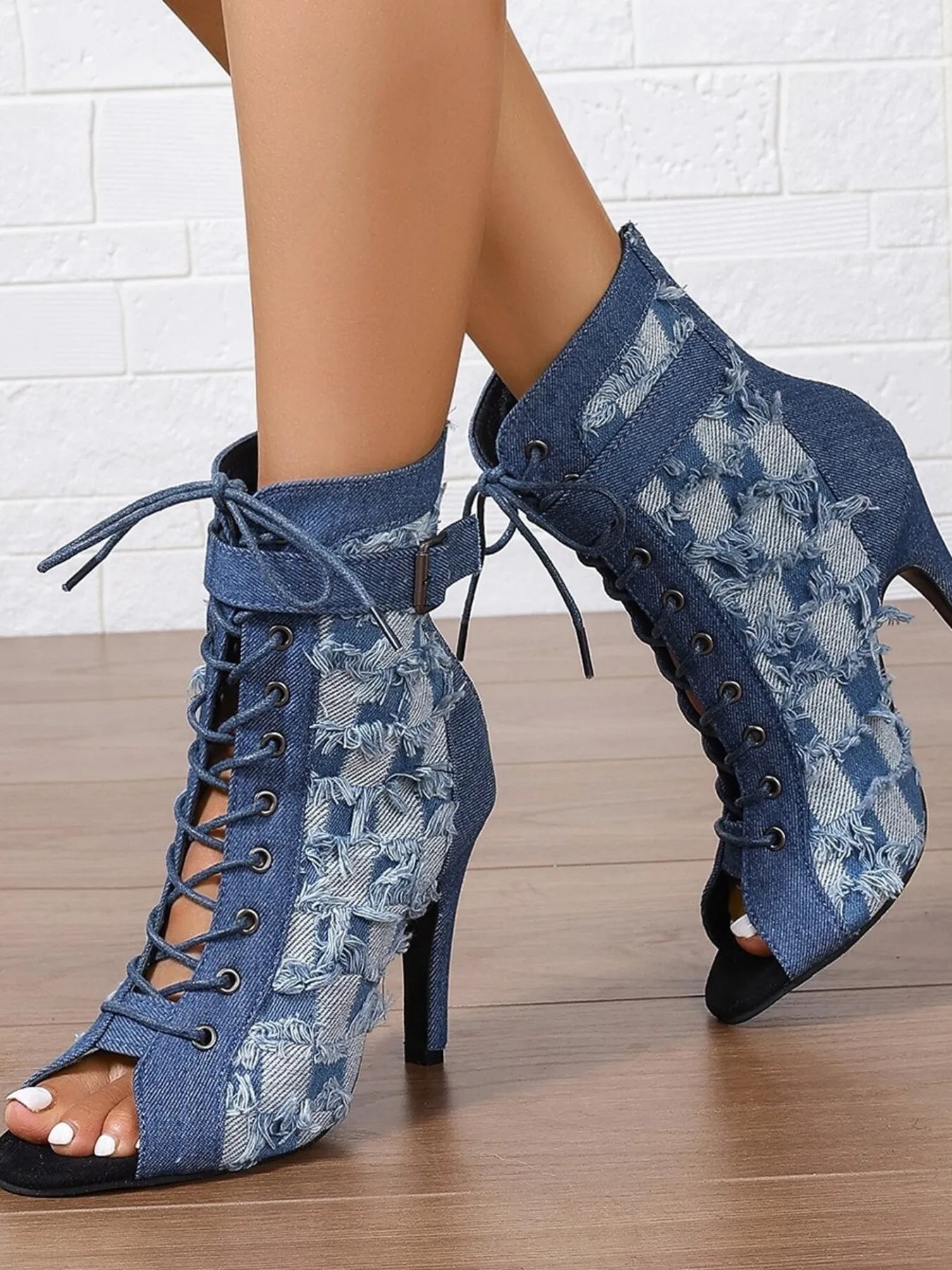 Denim peep-toe ankle booties with lace-up front, distressed frayed edges, ankle strap buckle, and stiletto heel