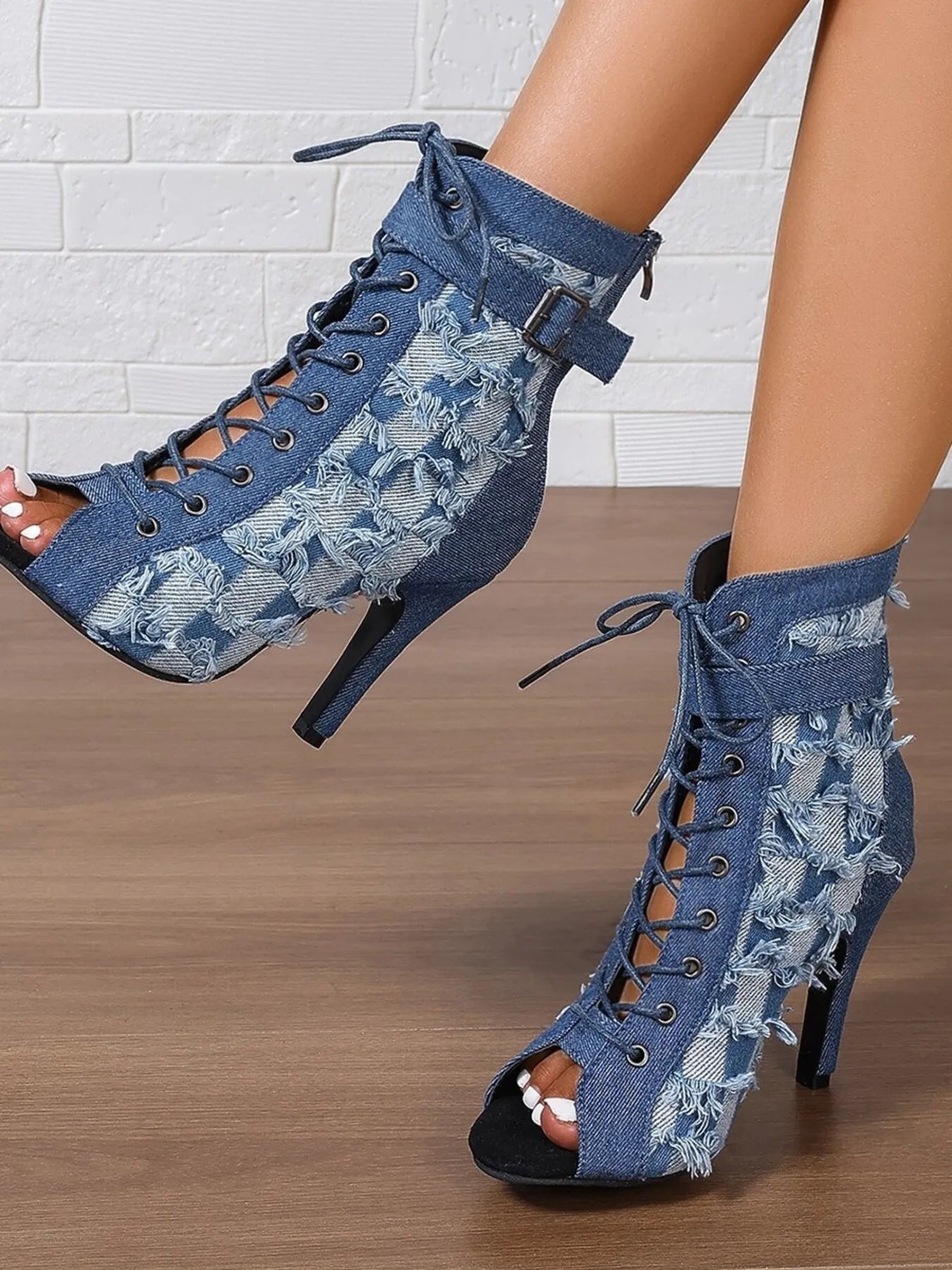 Denim peep-toe ankle booties with lace-up front, distressed frayed edges, ankle strap buckle, and stiletto heel