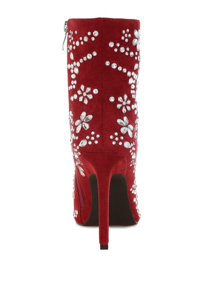 Red high-heeled boot with white floral embellishments on a white background