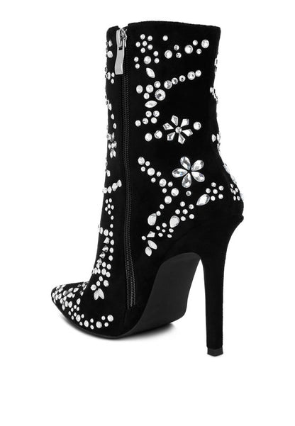 Black high-heeled boots with white floral embellishments on a white background