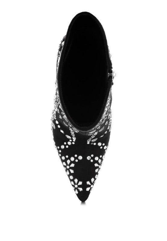 Black pointed-toe shoe with white floral patterns on a white background