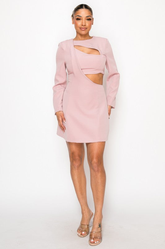 Woman wearing a long-sleeve mini dress with asymmetrical cutouts across the chest and midriff, styled against a plain white background.
