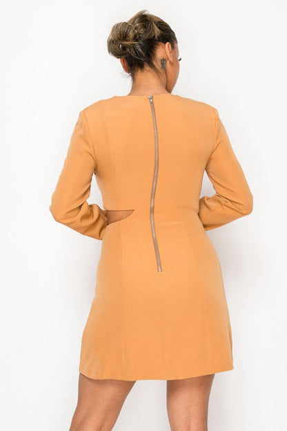 Woman wearing a long-sleeve mini dress with asymmetrical cutouts across the chest and midriff, styled against a plain white background.