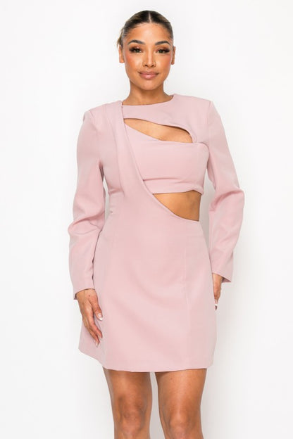 Woman wearing a long-sleeve mini dress with asymmetrical cutouts across the chest and midriff, styled against a plain white background.
