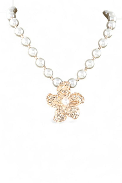 This image showcases a beautifully crafted pearl necklace featuring a standout flower-shaped pendant.
