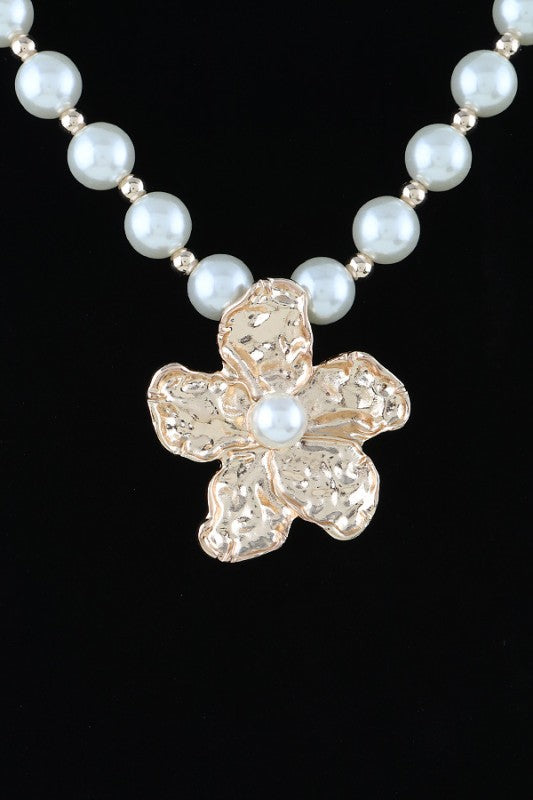 This image showcases a beautifully crafted pearl necklace featuring a standout flower-shaped pendant.