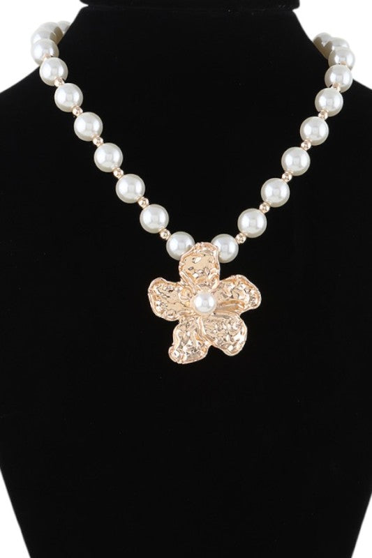 This image showcases a beautifully crafted pearl necklace featuring a standout flower-shaped pendant.