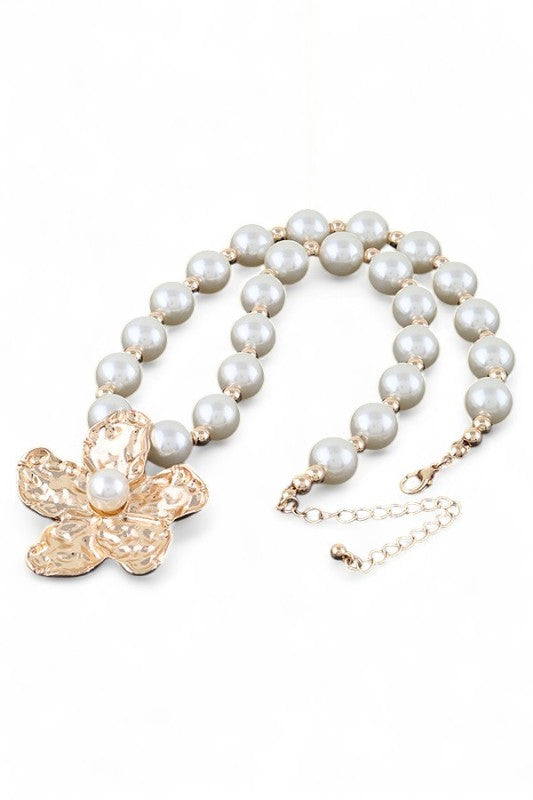 This image showcases a beautifully crafted pearl necklace featuring a standout flower-shaped pendant.