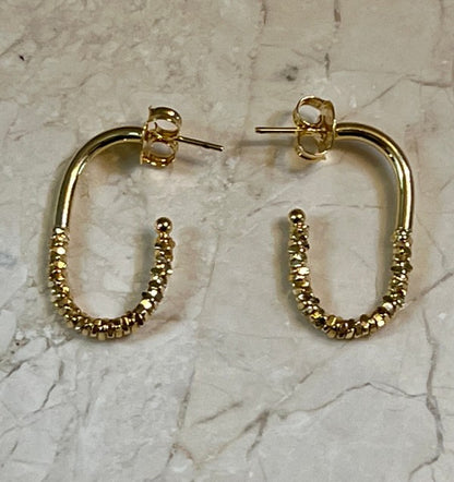 Sleek. Sparkly. Sophisticated. These Elongated Sparkle Gold Hoops are the perfect blend of modern minimalism and radiant charm. Designed to elongate the neckline and catch the light with every turn, they’re your go-to for both everyday elegance and special occasions.
