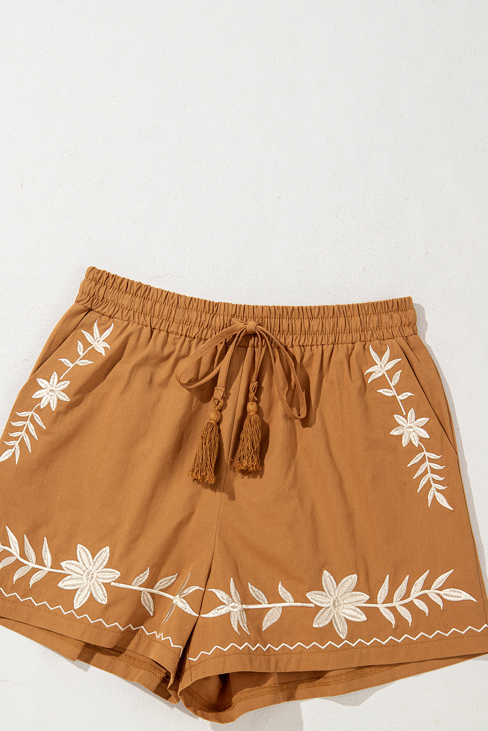 Khaki boho casual shorts with floral embroidery, tasseled drawstring, and elastic waistband for a comfy, chic summer look.