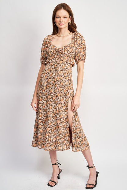 Woman models a chic floral midi dress with puff sleeves, a sweetheart neckline, and a trendy high slit, perfect for spring/summer.