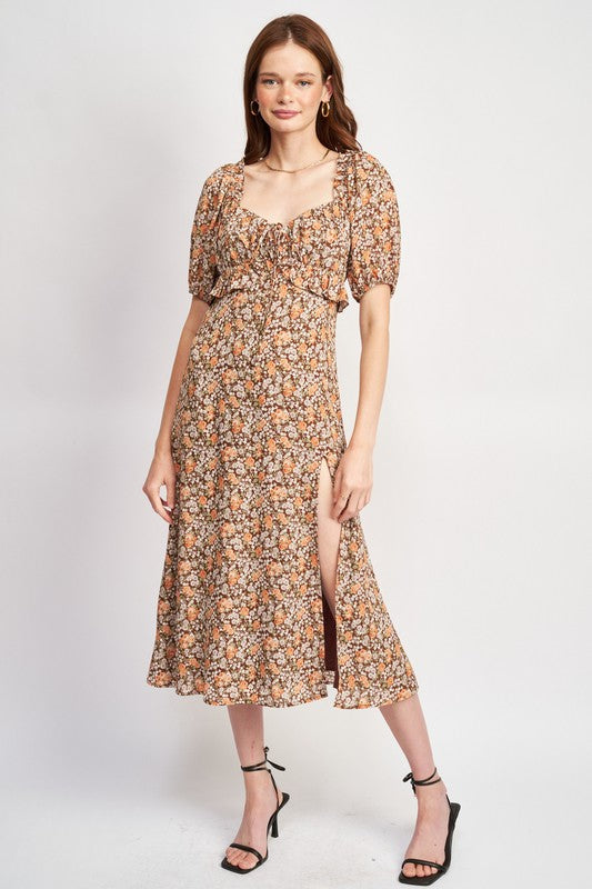 Woman models a chic floral midi dress with puff sleeves, a sweetheart neckline, and a trendy high slit, perfect for spring/summer.