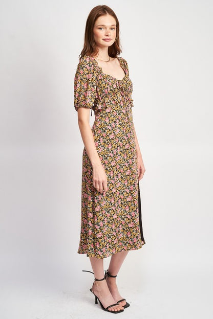 Woman models a chic floral midi dress with puff sleeves, a sweetheart neckline, and a trendy high slit, perfect for spring/summer, full side view.