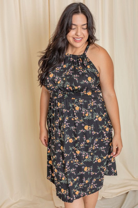 Woman wearing a floral halter neck midi dress with a flared skirt.
