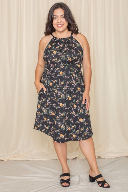 Woman wearing a floral halter neck midi dress with a flared skirt.