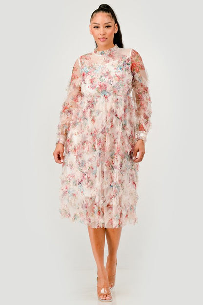 A woman wearing a Floral Ruffle Sheer Midi Dress, featuring an all over pastel floral print with cascading ruffle detailing for a soft, textured finish. 
